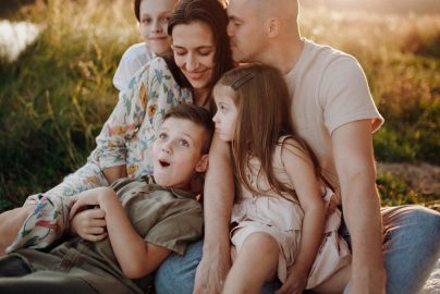 A joyful family enjoying quality time together on a sunset-lit meadow.