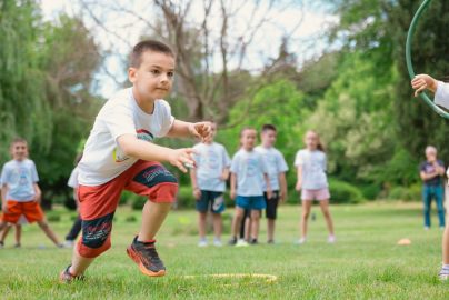 A group of children actively playing with hula hoops on a bright summer day in the park.