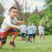 A group of children actively playing with hula hoops on a bright summer day in the park.